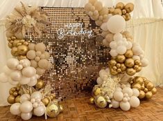 balloons and decorations are arranged on the floor in front of a backdrop that says happy birthday