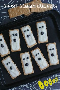 ghost graham crackers with white frosting and black eyes