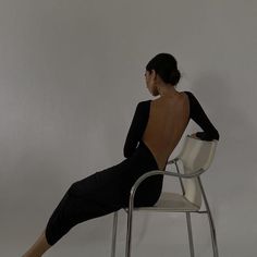 a woman sitting on a chair with her back turned