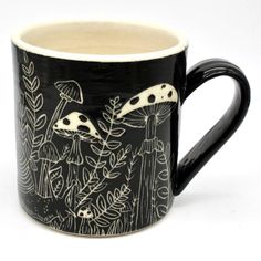 a black and white coffee mug with mushrooms on it