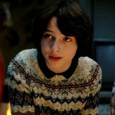 a woman in a sweater looking at the camera