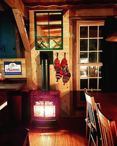 a wood stove sitting inside of a kitchen next to a wooden dining room table and chairs