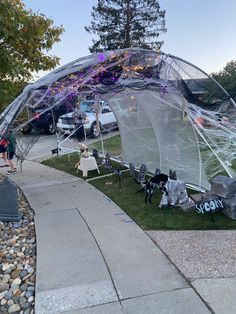 an outdoor tent set up on the side of a road with people walking around it