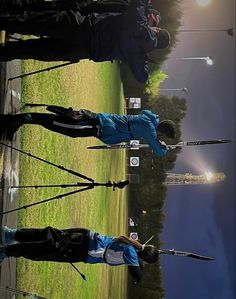 three people are standing on the grass with their golf clubs