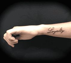 a person with a tattoo on their arm that says, loyapiy in cursive writing