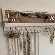 a wall mounted jewelry rack with many different necklaces