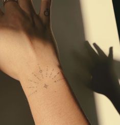 a person's arm with a tattoo on it and the sun in the background