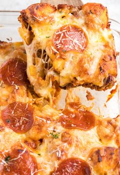 a slice of pepperoni pizza being lifted from a casserole dish