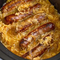 three sausages in a slow cooker with sauerkraut