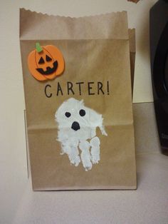 a brown paper bag with a ghost on it and a carved pumpkin in the center