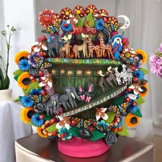 a colorful vase filled with animals and flowers