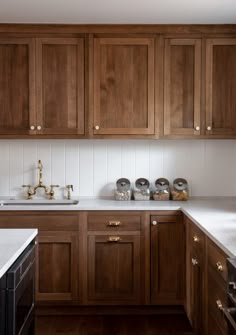 a kitchen with wooden cabinets and white counter tops