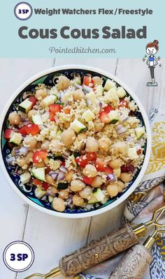 a white bowl filled with couscous salad on top of a blue and yellow table cloth