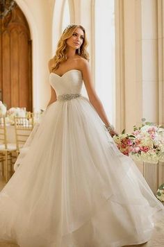 a woman in a white wedding dress posing for the camera