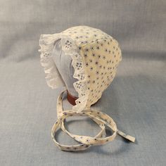 Made to Order. Crafted with love and care from 100% cotton and lace trim, this handmade cotton baby bonnet is a charming accessory for your little one. Made from soft, breathable cotton, it ensures comfort and style in one adorable package. The delicate craftsmanship of this bonnet adds a touch of artisanal flair to your baby's ensemble. Whether worn for a special occasion or as a daily accessory, this bonnet is both practical and delightful. Its timeless design and high-quality materials make it a thoughtful gift for new parents or a sweet addition to your baby's wardrobe. Add a touch of handmade beauty to your baby's look with this lovely cotton baby bonnet. Perfect for protecting your baby's delicate skin from the sun or wind, this bonnet is as functional as it is adorable. The adjustab White Cotton Bonnet As A Gift, Adjustable Cream Bonnet As A Gift, White Cotton Bonnet As Gift, Adjustable Cream Bonnet As Gift, Adjustable Cotton Bonnet With Lace Trim, White Cotton Bonnet For Spring, Adjustable Cotton Vintage Bonnet, Fitted Cotton Bonnet With Lace Trim, Spring White Cotton Bonnet