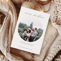 a christmas card sitting on top of a pile of sweaters