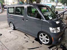 a small gray van parked on the side of the road