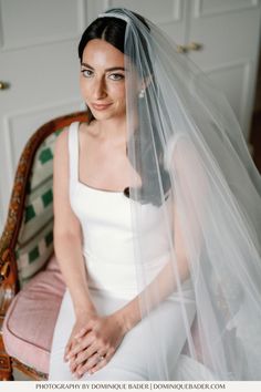 a woman sitting in a chair wearing a wedding veil