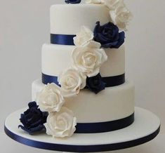 a three tiered wedding cake with blue and white flowers