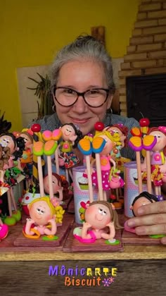 a woman sitting at a table with lots of toy figurines in front of her