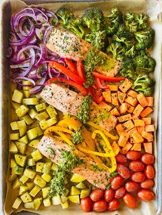 a tray filled with vegetables and fish next to broccoli