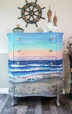 a painted dresser with an ocean scene on it