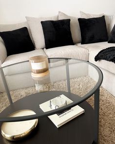 a living room with a couch, coffee table and pillows on the carpeted floor