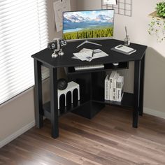 a desk with a computer on top of it in front of a window and wooden floors