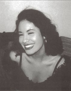 a black and white photo of a woman smiling