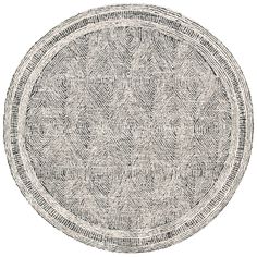 a round rug with an intricate design on the center and sides, in grey tones