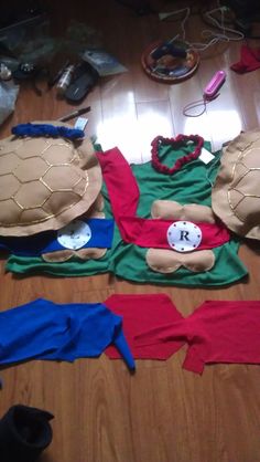 several pieces of clothing are laid out on the floor, including turtle tops and leggings