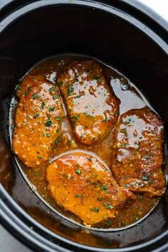 pork chops are being cooked in the slow cooker