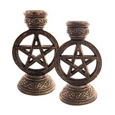 two metal candlesticks decorated with an inverted pentagram