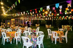 tables and chairs are set up in the grass for an outdoor party with bunting