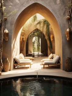 an outdoor swimming pool with lounge chairs and potted plants on the wall next to it