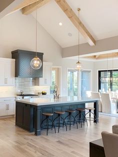 a large kitchen with an island and bar stools