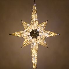 a lighted star hanging from the ceiling in front of a dark sky with stars on it