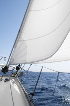 the sailboat is sailing in the open ocean on a sunny day with clear blue skies