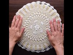 two hands touching the top of a doily