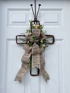 a cross made out of newspaper paper with flowers on the front and side hanger