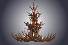 the antler chandelier is made from wood and has candles lit inside it