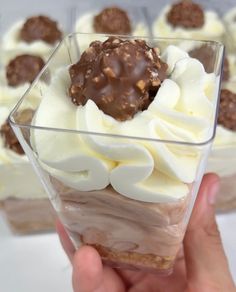 there is a dessert in the glass with white frosting and chocolate toppings on top