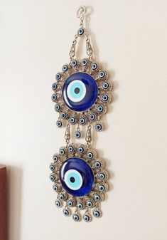 There are 2 Large Evil eye beads and 40 tiny evil eye beads on the silver hanging. Blue evil eye beads are 7 cm(2.7 in) Width of the zamak evil eye is 11.5 cm(4.5 in) Height of the metal evil eye hanging is 32 cm(12.5 in) You can place this Turkish ornament in your home or Office for protection. For more evil eye hangings, click the link below; https://www.etsy.com/shop/EyeDesignsbyGG?ref=search_shop_redirect&section_id=30211705 Bohemian Blue Evil Eye Bracelet For Festival, Blue Evil Eye Bracelet For Festivals, Traditional Blue Evil Eye Jewelry, Handmade Blue Evil Eye Bracelet, Bohemian Silver Evil Eye Bracelet, Evil Eye Hanging, Evil Eye Decor, Jute Craft, Evil Eye Wall Hanging