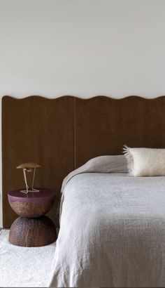 a bed with a wooden headboard and white sheets