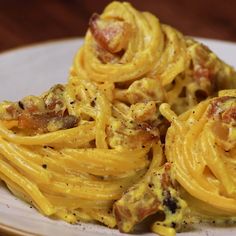 a white plate topped with pasta and bacon