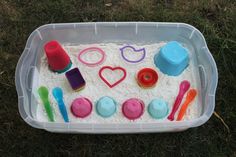 a plastic tray filled with sand and toys