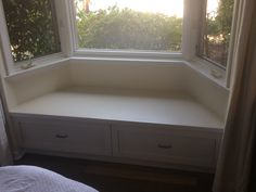 a window seat with two drawers in front of it