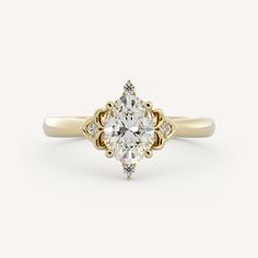 a yellow gold engagement ring with an oval cut diamond in the center and two small round diamonds on each side