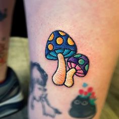 a colorful mushroom tattoo on the leg