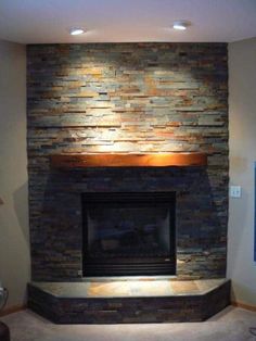 a living room with a fire place and stone wall